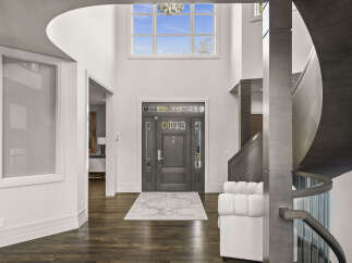 Step into luxury with this stunning entryway, showcasing a grand staircase and soaring ceilings.