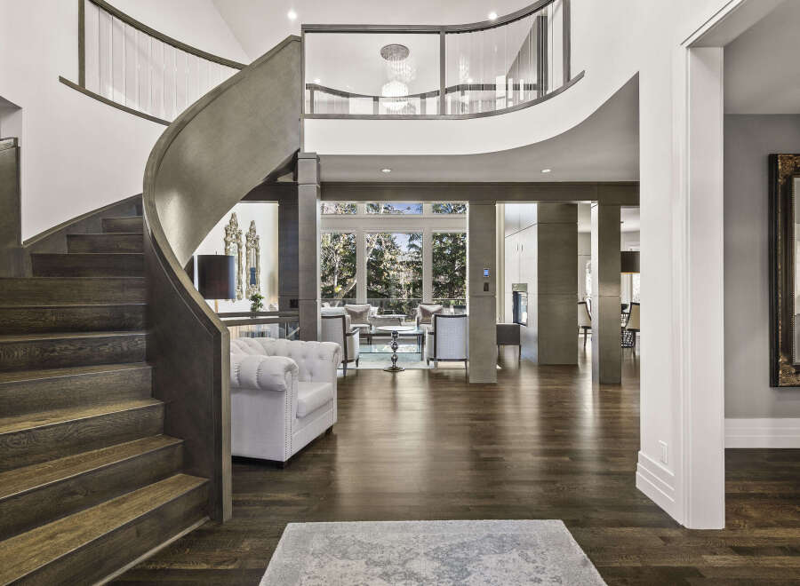 Step into luxury with this stunning home featuring a grand, curved staircase and exquisite hardwood floors.