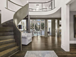 Step into luxury with this stunning home featuring a grand, curved staircase and exquisite hardwood floors.