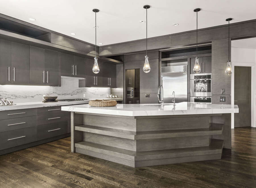 This stunning kitchen boasts a modern design with sleek, dark wood cabinetry and a spacious marble countertop.