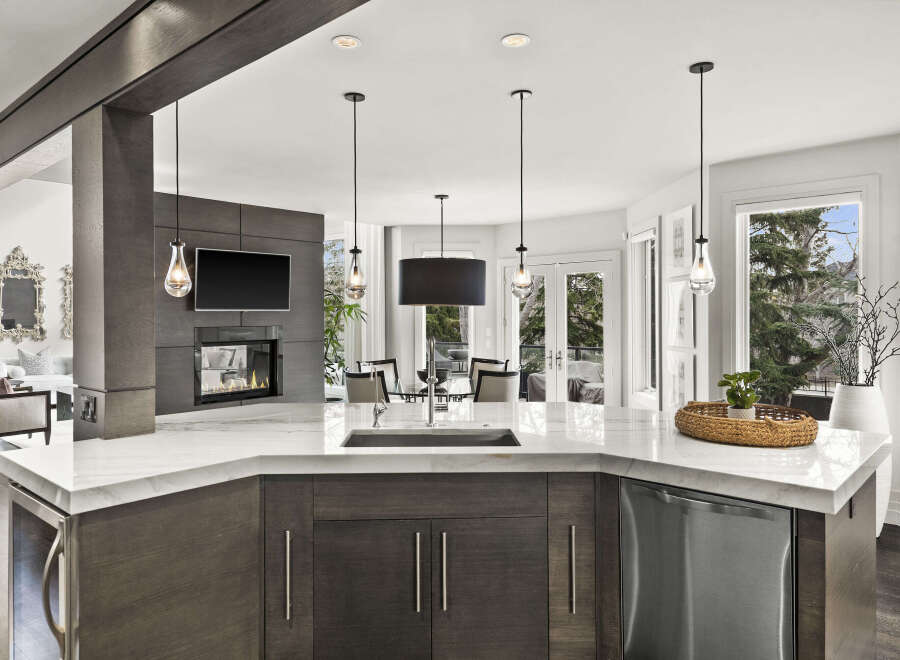 This stunning kitchen boasts a modern design with a sleek marble countertop and dark wood cabinetry, creating an elegant and inviting space.