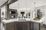 This stunning kitchen boasts a modern design with a sleek marble countertop and dark wood cabinetry, creating an elegant and inviting space.