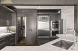 This stunning kitchen boasts a modern design with sleek, dark wood cabinetry and high-end stainless steel appliances.