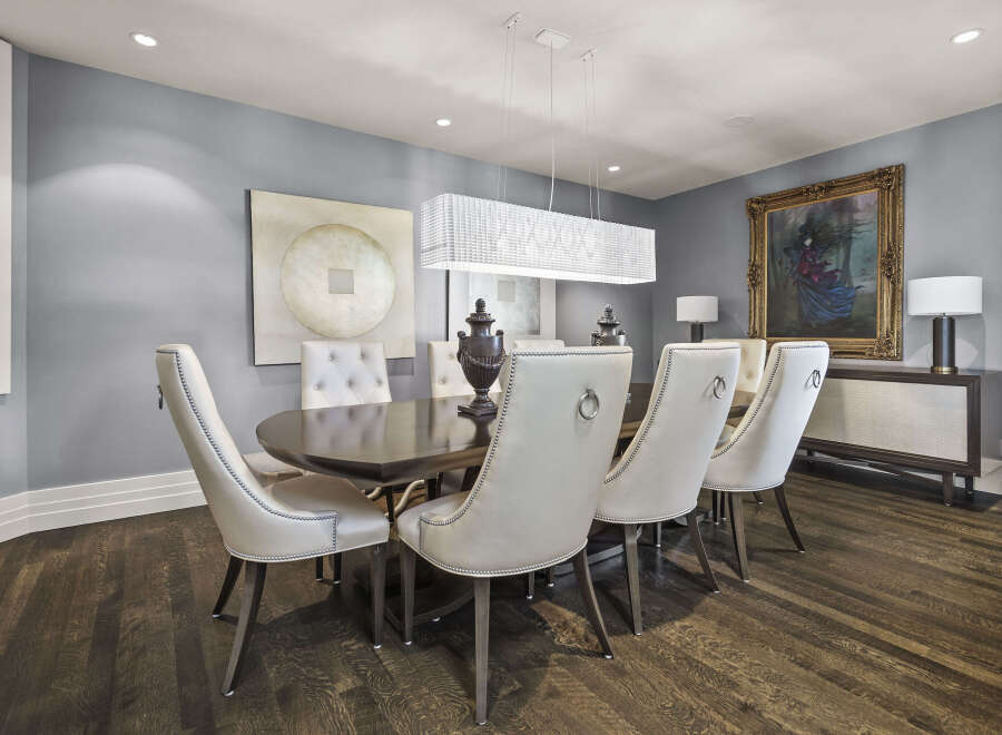 Step into luxury with this stunning dining room, featuring a modern chandelier that illuminates the space.