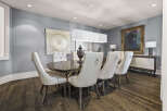 Step into luxury with this stunning dining room, featuring a modern chandelier that illuminates the space.
