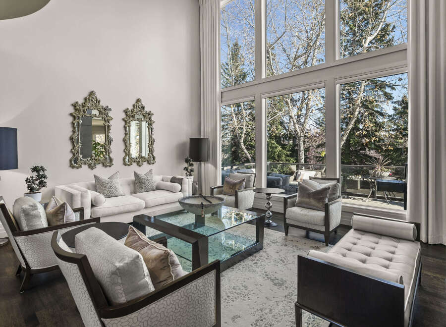 Experience luxury living in this stunning property, featuring a spacious living room bathed in natural light from expansive windows.