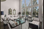 Experience luxury living in this stunning property, featuring a spacious living room bathed in natural light from expansive windows.
