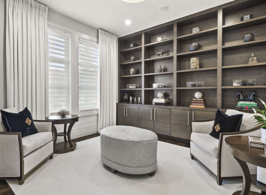 Step into luxury with this stunning home office, featuring custom built-in shelving and ample storage.