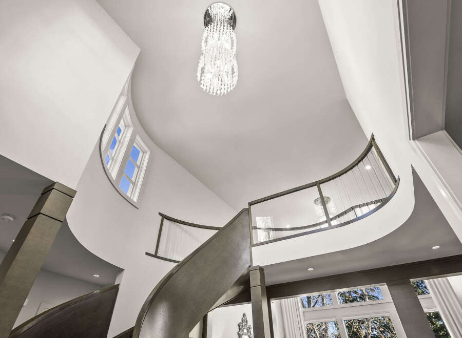 This stunning property features a grand, curved staircase, a focal point of the home's elegant design.