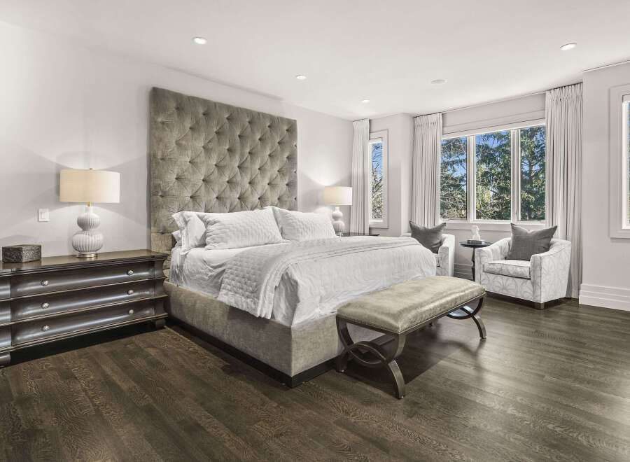 Step into luxury with this stunning bedroom, featuring a tufted headboard and elegant furnishings.