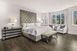 Step into luxury with this stunning bedroom, featuring a tufted headboard and elegant furnishings.