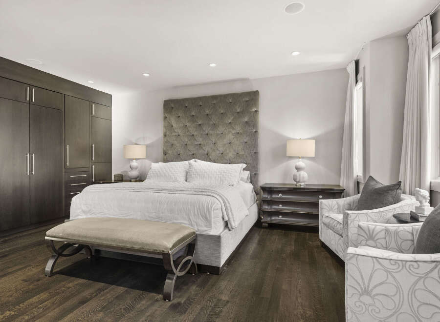 Step into luxury with this stunning bedroom featuring a plush, tufted headboard and a comfortable bed.