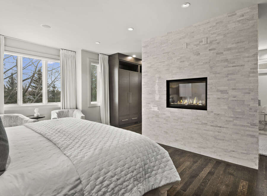 Experience luxury in this stunning bedroom featuring a modern fireplace and elegant design.