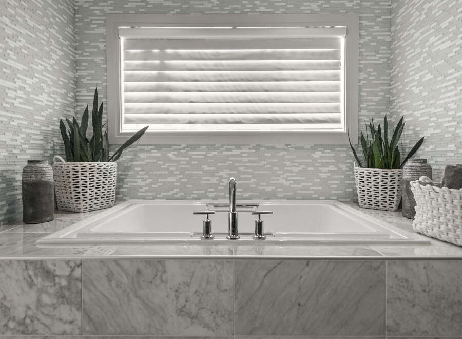 Indulge in the luxury of this spa-like bathroom, featuring a pristine white bathtub and elegant marble accents.