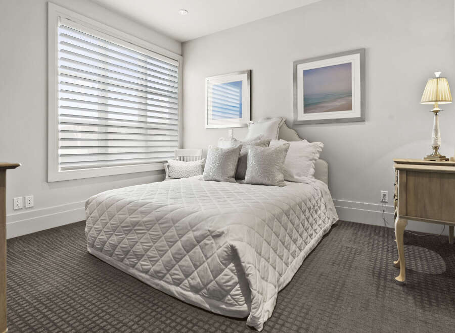 This elegant bedroom offers a serene retreat with its neutral color palette and plush textures.