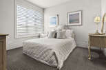 This elegant bedroom offers a serene retreat with its neutral color palette and plush textures.