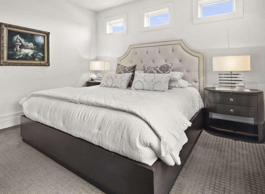 Step into luxury with this stunning bedroom, featuring a plush, tufted headboard and elegant nightstands.