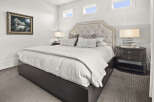 Step into luxury with this stunning bedroom, featuring a plush, tufted headboard and elegant nightstands.