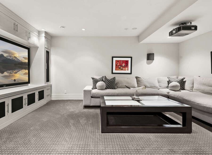This stunning living room boasts a modern design with a large sectional sofa, perfect for relaxing and entertaining.