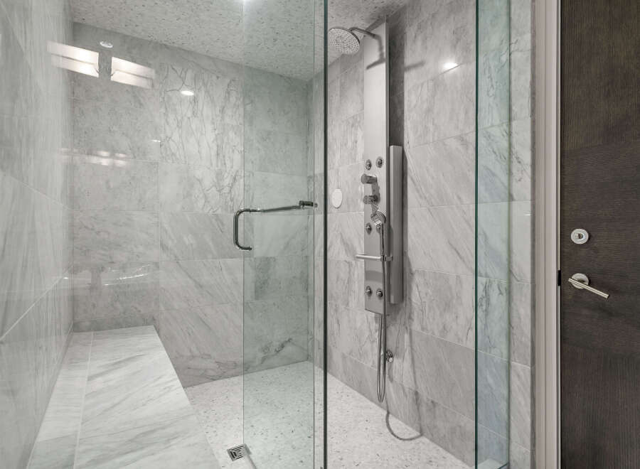 Step into luxury with this stunning shower featuring elegant marble tiling and a sleek glass enclosure.