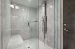 Step into luxury with this stunning shower featuring elegant marble tiling and a sleek glass enclosure.