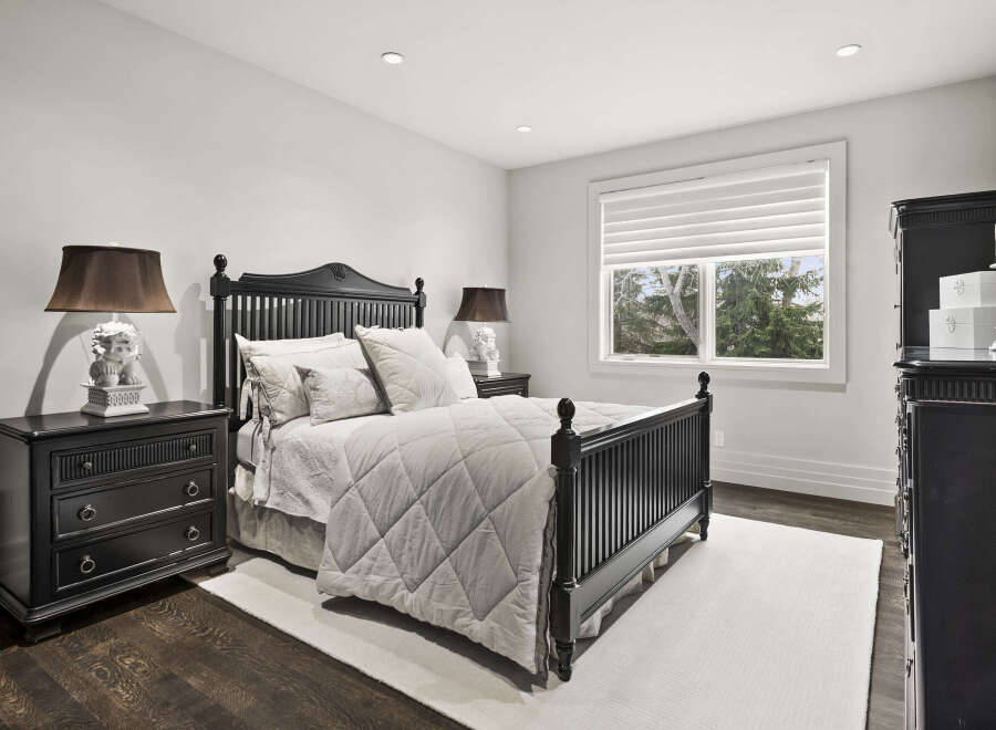 This elegant bedroom features a sophisticated design with a dark wooden bed frame and matching nightstands.