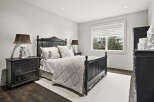 This elegant bedroom features a sophisticated design with a dark wooden bed frame and matching nightstands.