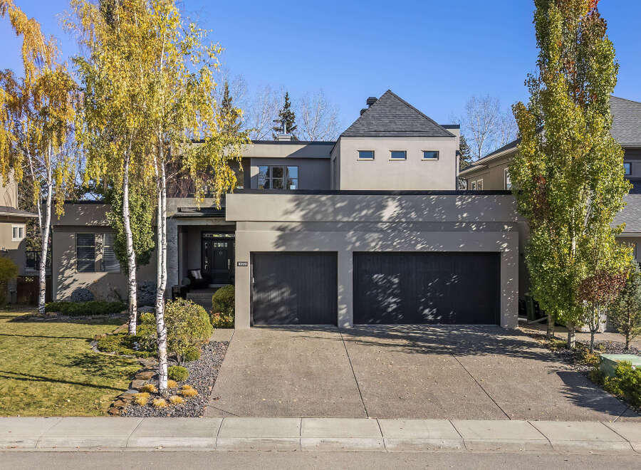 This stunning modern home boasts a sleek exterior with a two-car garage and a beautifully landscaped front yard.