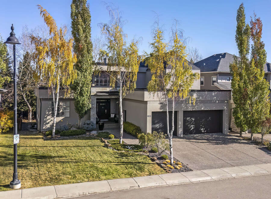 This stunning modern home boasts a sleek exterior design with a spacious driveway and lush landscaping.