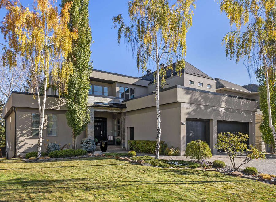 This stunning property boasts a modern architectural design with a sleek exterior and lush landscaping.