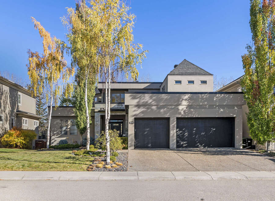This stunning modern home boasts a sleek exterior with a two-car garage and a beautifully landscaped front yard.