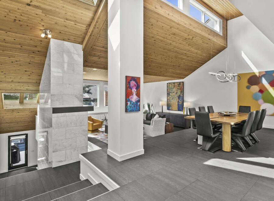 This stunning modern home boasts a unique architectural design with a vaulted wood ceiling and an open floor plan.