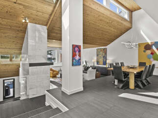 This stunning modern home boasts a unique architectural design with a vaulted wood ceiling and an open floor plan.