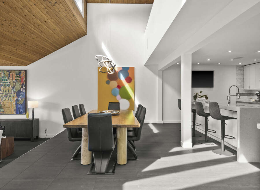 This stunning modern dining room boasts a sleek design with a beautiful wooden table and stylish black chairs.