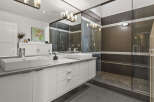 This stunning bathroom boasts a modern design with sleek white cabinetry and a luxurious double vanity.