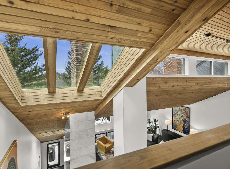 This stunning property boasts a unique architectural design, featuring a striking wooden ceiling and expansive skylights that flood the interior with natural light.