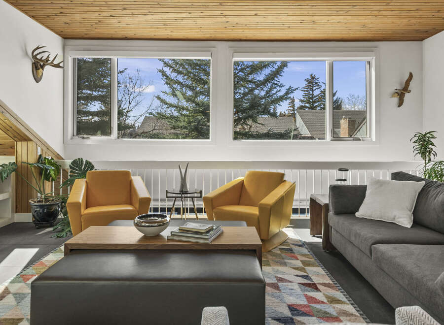 Step into this inviting living space, featuring a cozy seating area with two stylish yellow armchairs and a comfortable gray sofa.