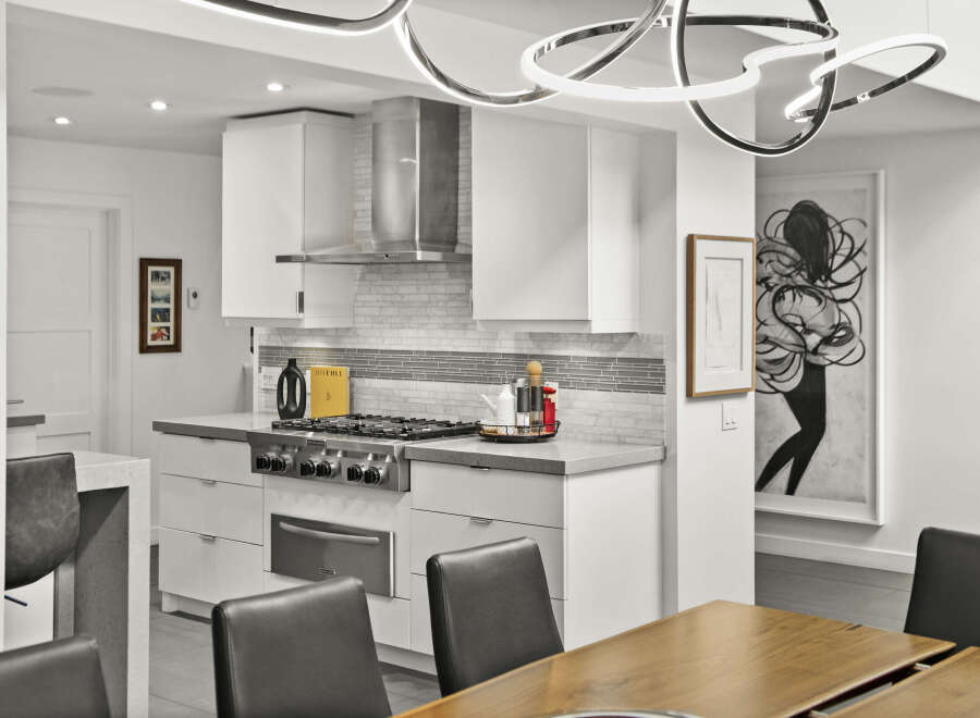 This stunning kitchen boasts modern design with sleek white cabinetry and stainless steel appliances.