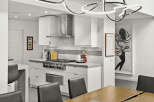 This stunning kitchen boasts modern design with sleek white cabinetry and stainless steel appliances.