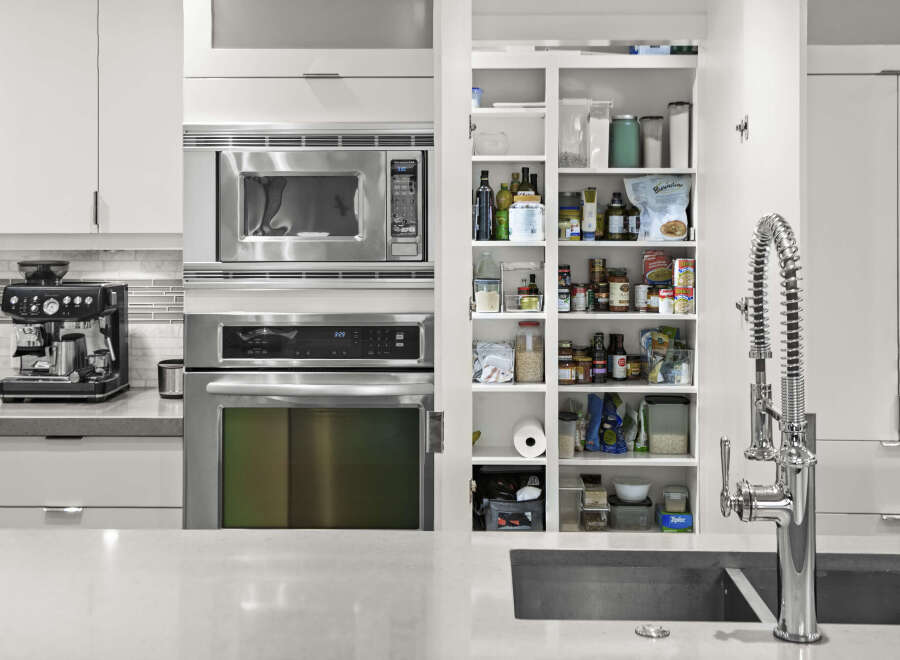This modern kitchen boasts stainless steel appliances, including a microwave and oven, seamlessly integrated into the sleek cabinetry.