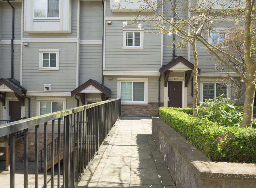Discover modern living in this stunning townhome, featuring a beautifully landscaped entrance and a welcoming facade.