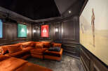 Step into luxury with this stunning home theater! Featuring a plush, orange sectional sofa, a starry ceiling, and movie posters, this space is designed for ultimate relaxation and entertainment.