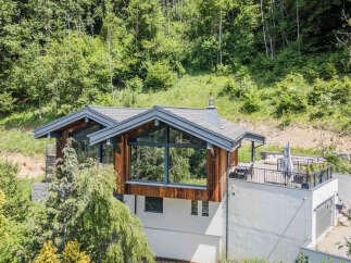 Discover a stunning modern home nestled in a serene, wooded setting.