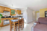 Discover this charming property featuring a well-equipped kitchen with wooden cabinetry and a cozy dining area.