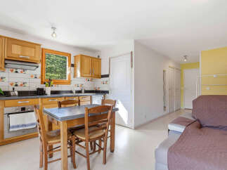 Discover this charming property featuring a well-equipped kitchen with wooden cabinetry and a cozy dining area.