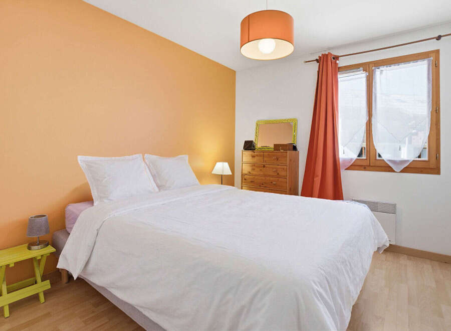 This cozy bedroom features a comfortable bed with crisp white linens, perfect for a relaxing retreat.