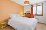 This cozy bedroom features a comfortable bed with crisp white linens, perfect for a relaxing retreat.