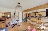 Discover the charm of this inviting property, featuring a stylish hanging chair and a cozy living space.