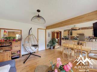 Discover the charm of this inviting property, featuring a stylish hanging chair and a cozy living space.