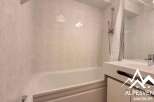 Discover this charming bathroom featuring a bathtub and a stylish sink.